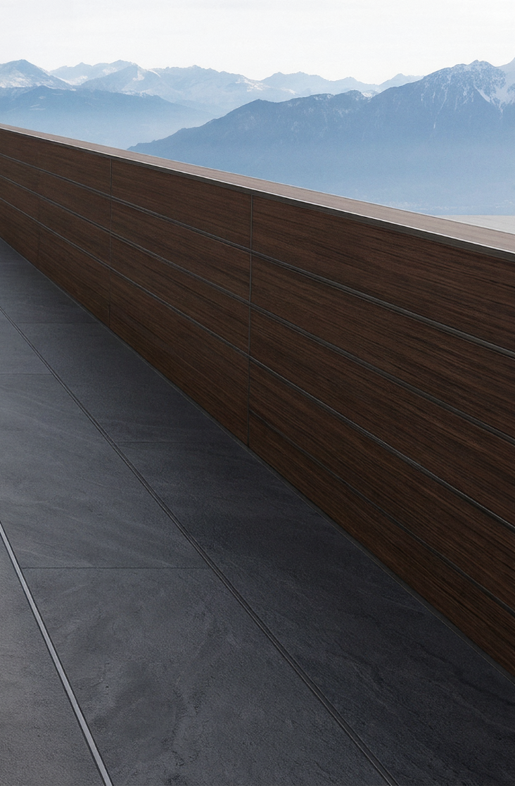 LOTTERS Aluminium-Bodensystem für moderne Terrassen Moderner Balkon mit Holzgeländer und Blick auf bergige Landschaft im Hintergrund.